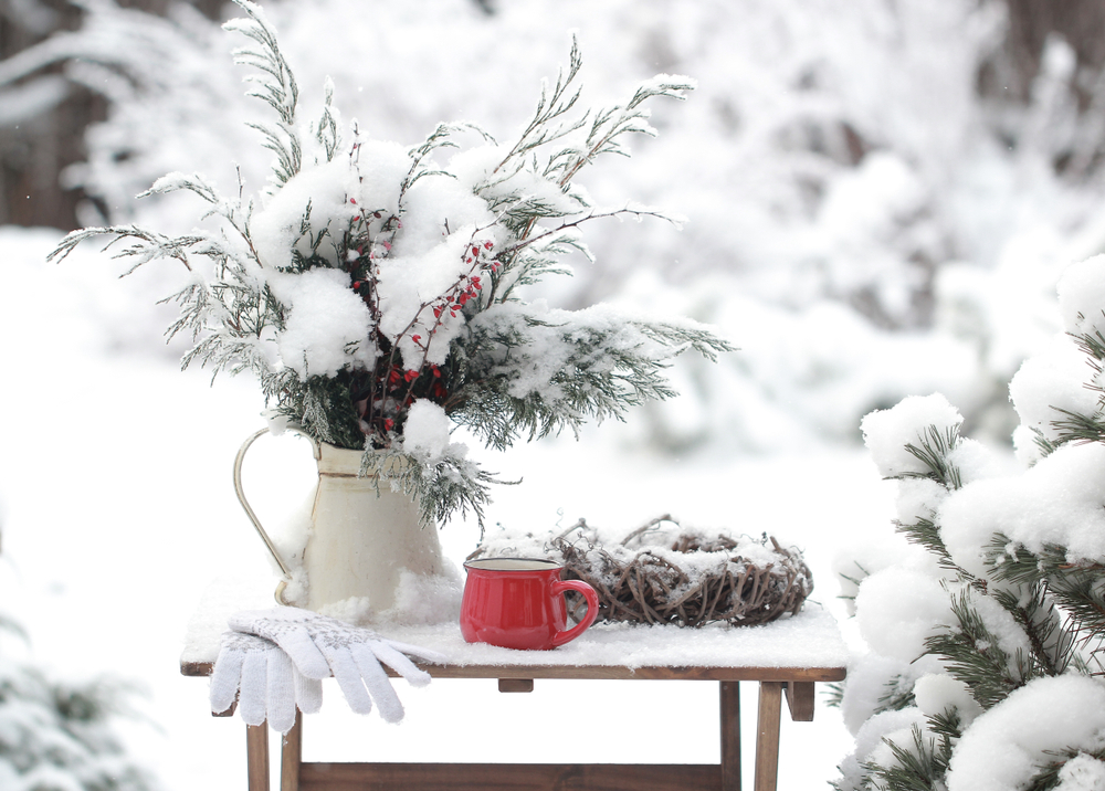 Garden table and flowers covered in snow