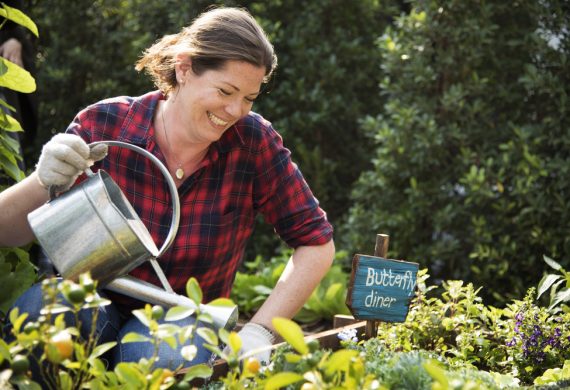 A Woman Smiling While She Gardens